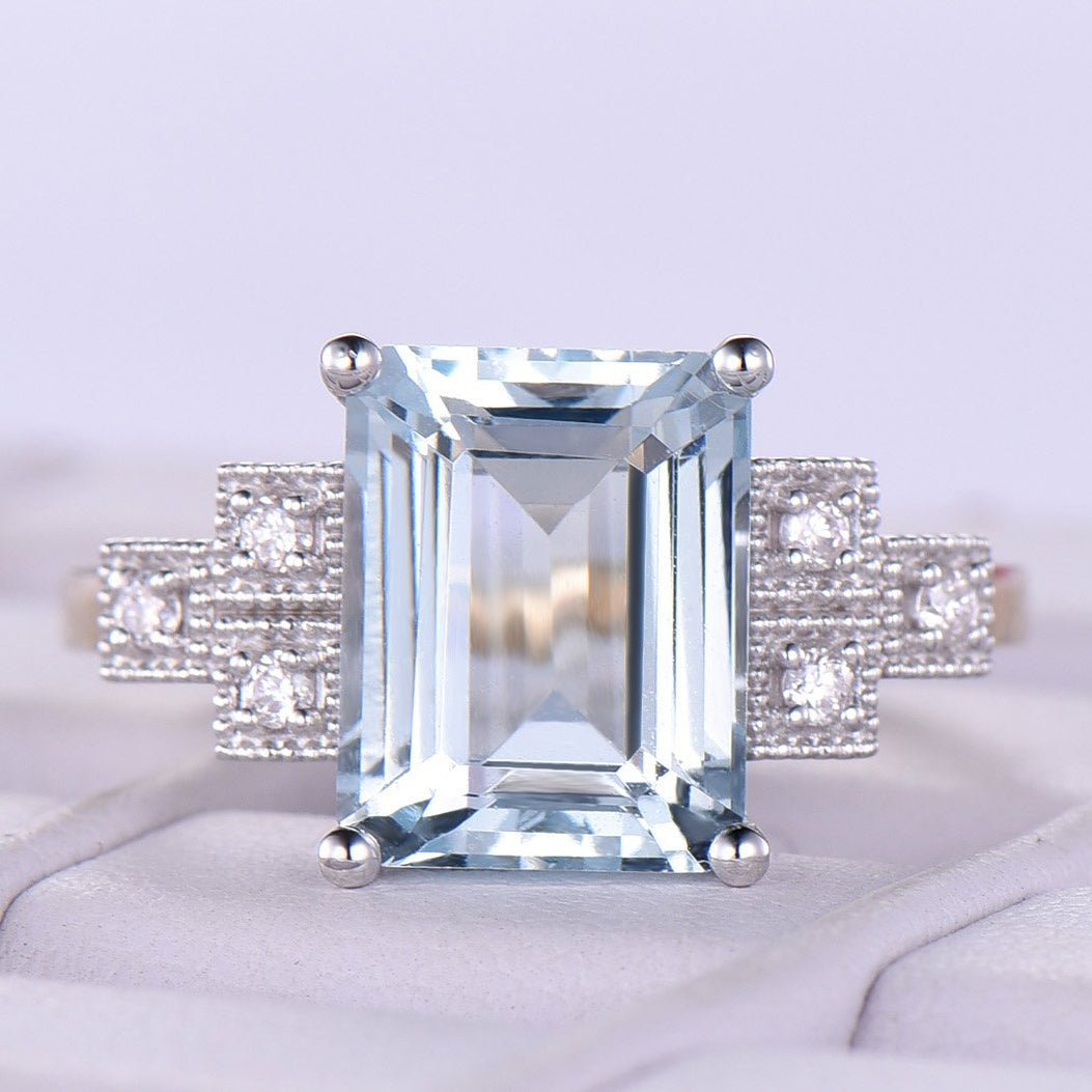 Emerald cut aquamarine with three shipping small diamonds in a triangle shape March birth